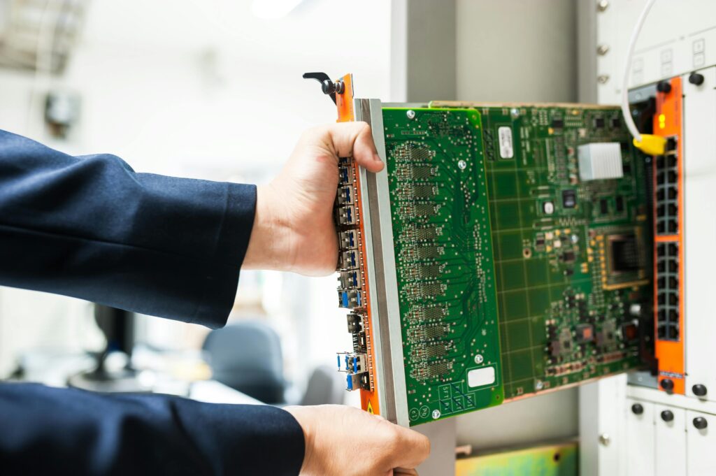 pexels-photo-19226354-19226354 A technician inserts a circuit board into a server rack, illustrating technology and connectivity.